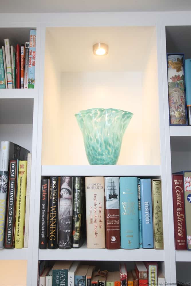 A vase inside a white bespoke shelving unit