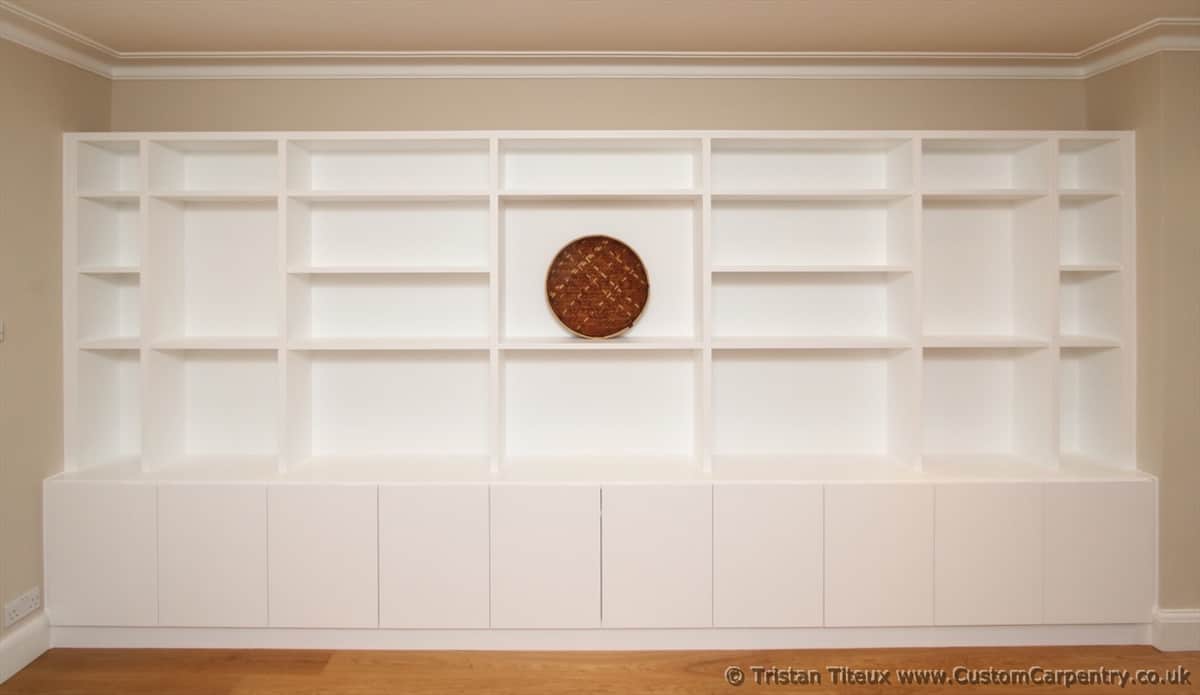 Bespoke shelving hand painted white, with random compartments, and deeper cupboard section below