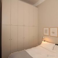 Bedroom with tall fitted wardrobes and a bed