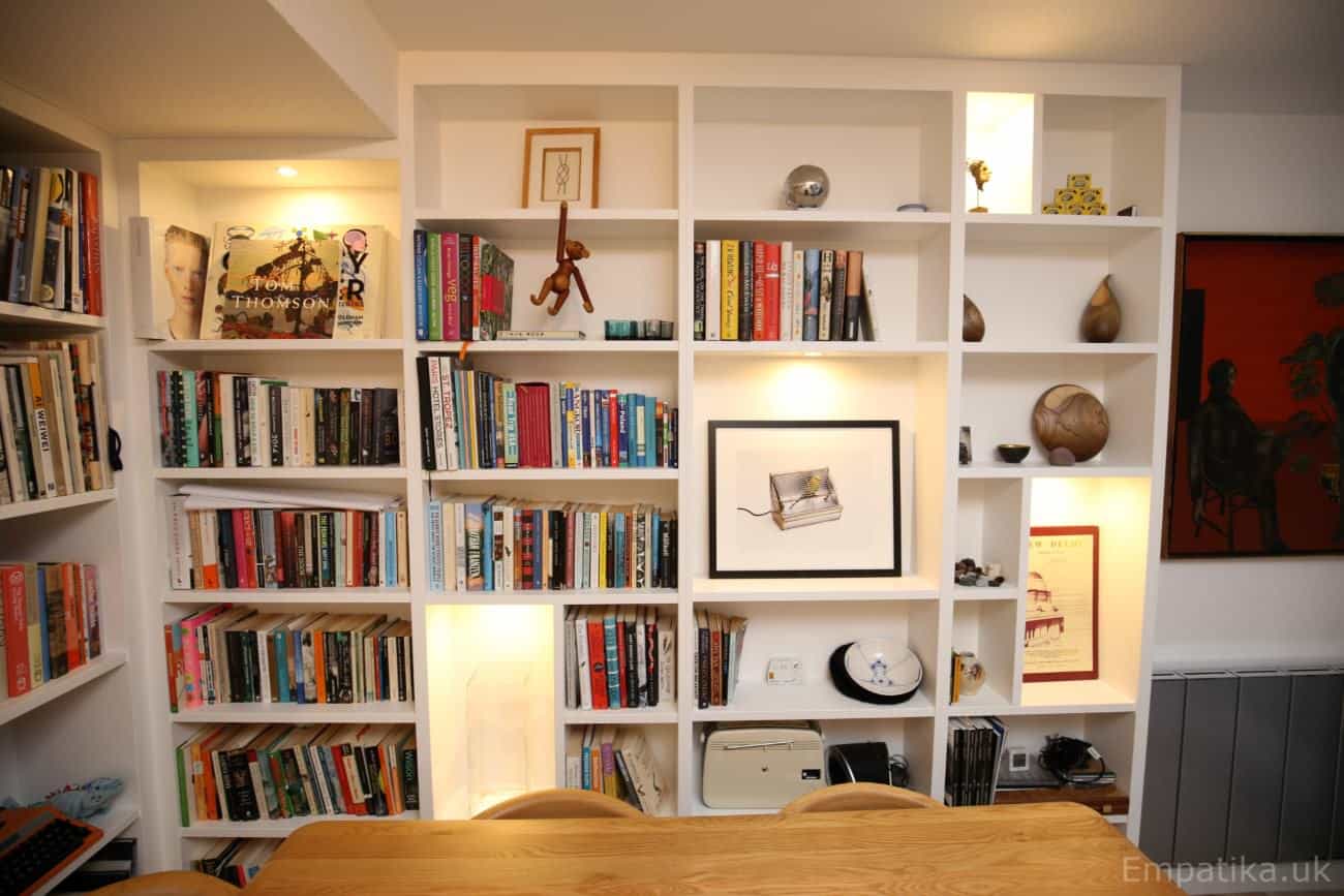 Fitted floor to ceiling display unit library bookcases with accent asymmetrical shelves with LED lights