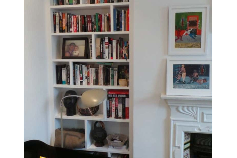 Wall recessed White painted alcove bookcase beside a fireplace