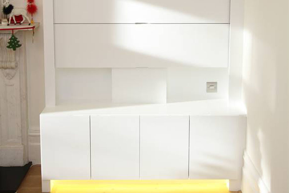 Closer look at White painted custom media unit with shelves and vertical-sliding covers for wall-mounted TV