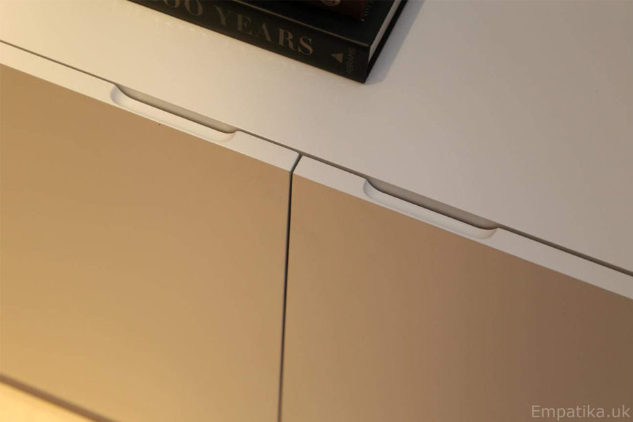 Close up of White media unit closet doors with edge pockets for easy open