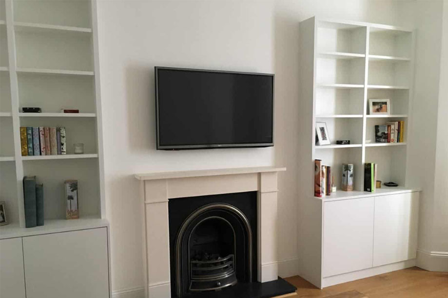 Contemporary White painted alcove cupboards in a living room with a fireplace and wall-mounted TV in between