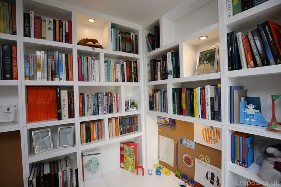 Closer view of home office corner library bookcase with random shelves with LED light