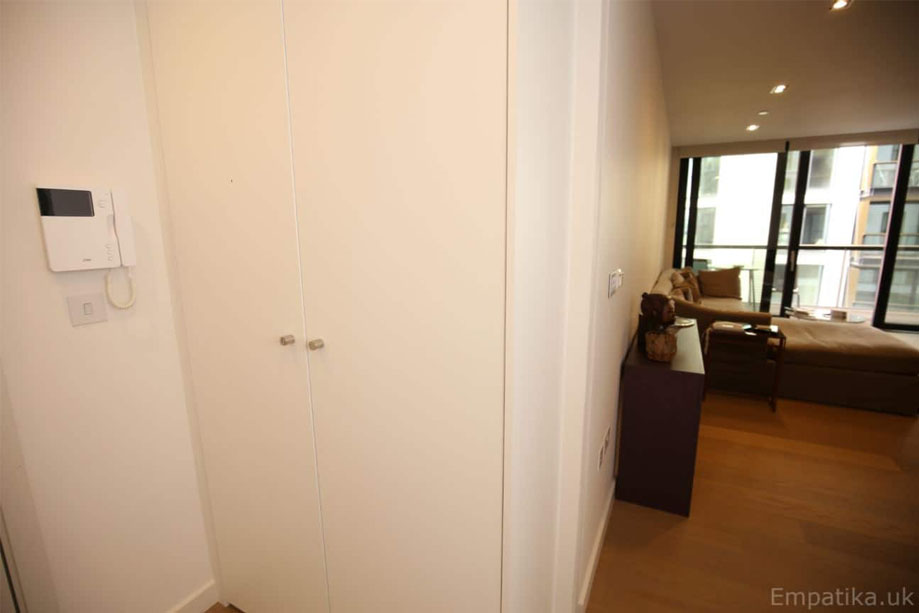 Fitted White painted storage cupboard with 2 tall slim doors and small steel handles