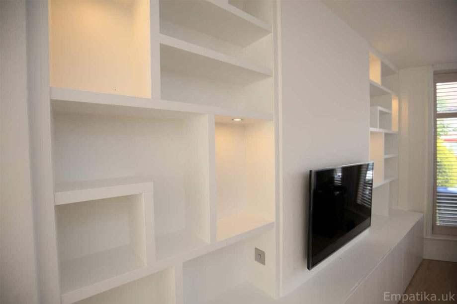 Display unit with LED light alcove shelves and low media table with closets