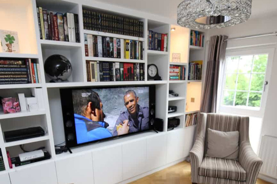 Built in media unit with ceiling high bookcase and accent shelves with LED light