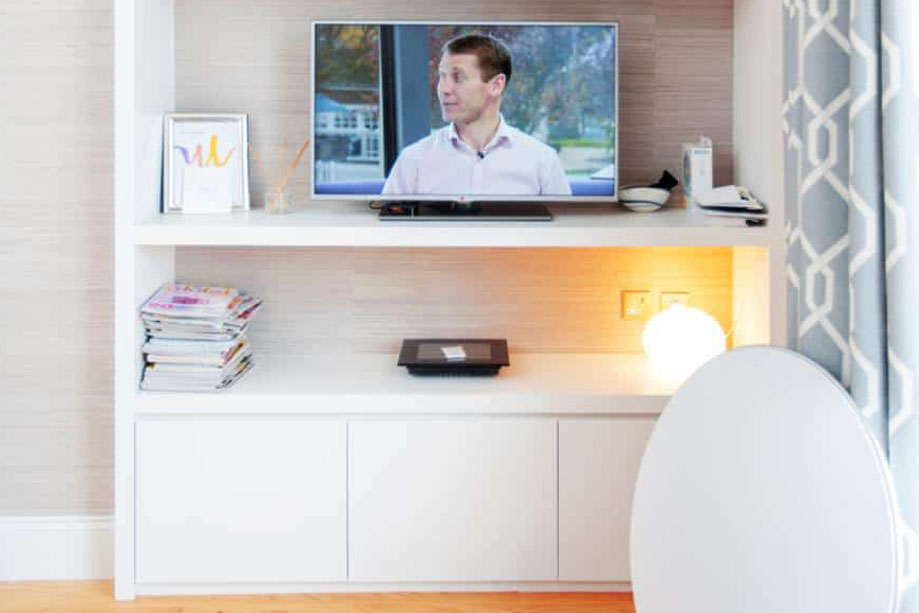 Floor to ceiling Whte painted media unit with a flatscreen TV on the second shelf