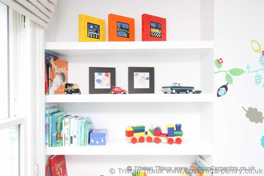 Custom wall recessed shelves painted White by the window of children's bedroom