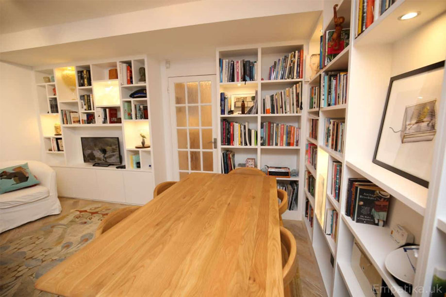 View of living room interiors with custom media unit and matching L-shaped display unit all painted White