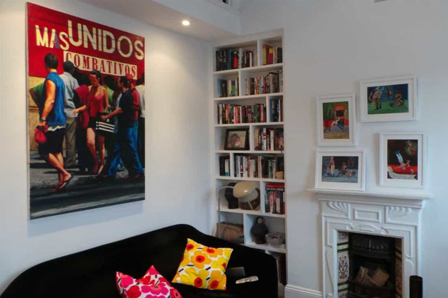 2 slim and tall White painted alcove bookcases on either side of a fireplace