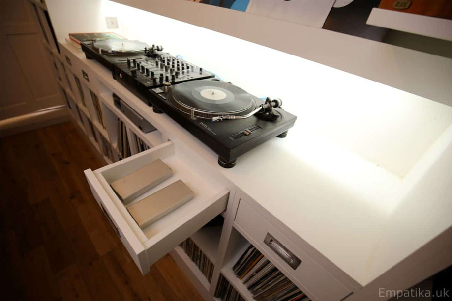 Closer view of media storage unit with LED panel backlight on center shelf containing a DJ turntable