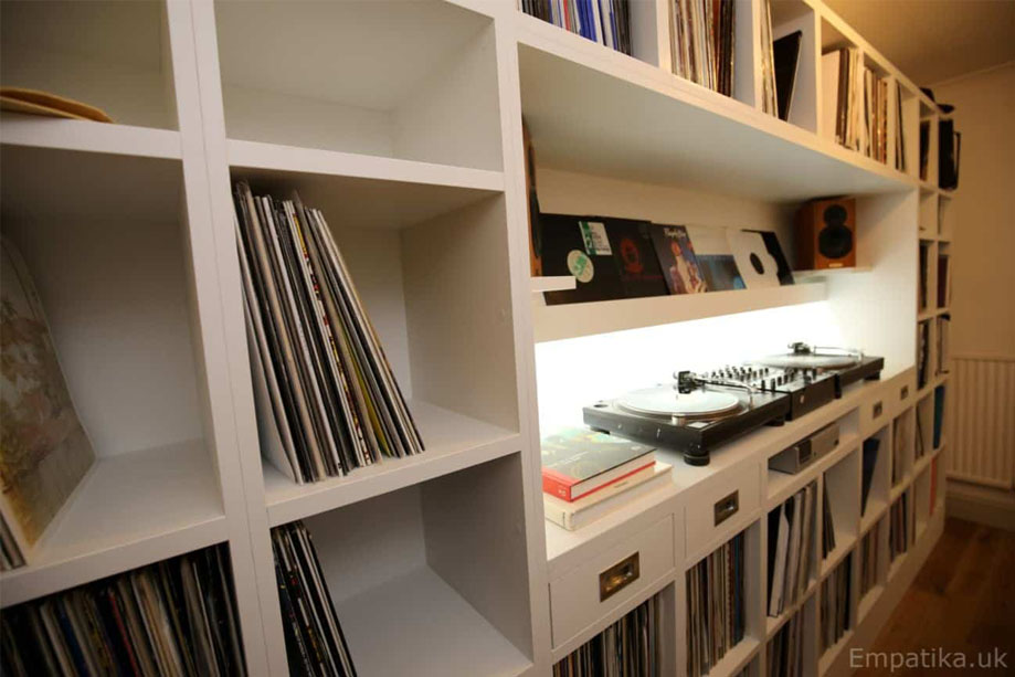 Left side view of bespoke record storage unit with square shelves surrounding a turntable storage space with speakers in the center