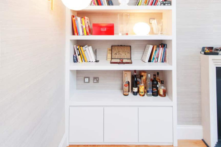 Built-in fitted floor to ceiling media shelves with bottom closets all painted White