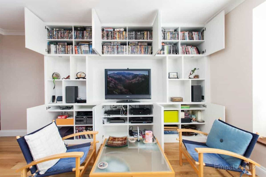 Floor to ceiling built in wall storage unit with closet doors open showing lots of shelves inside all painted White