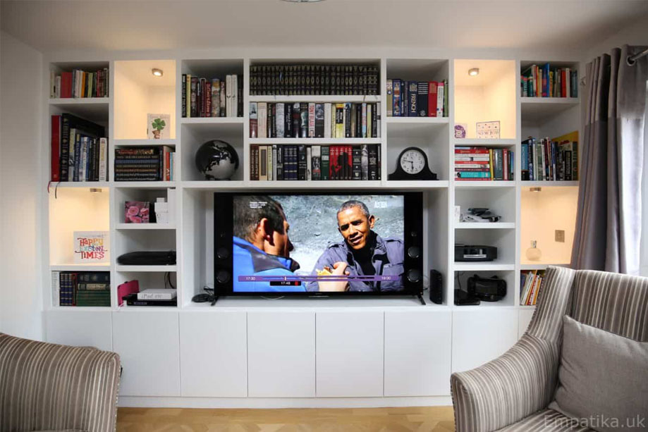 Full view of White painted media unit with ceiling high library bookcase with 4 LED light accent shelves