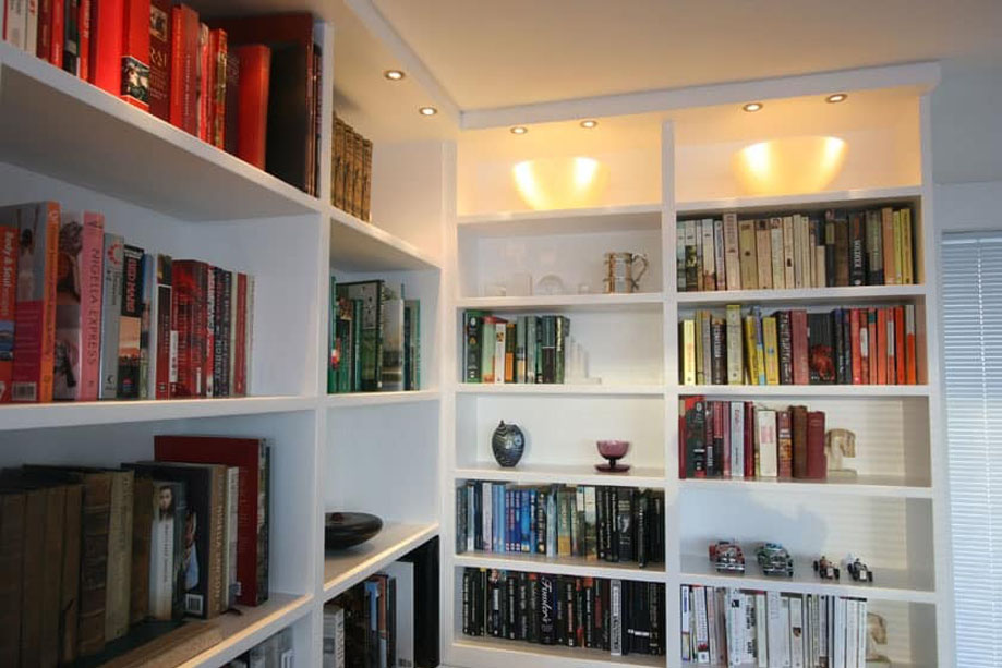 White painted ceiling high library bookcase built on two walls