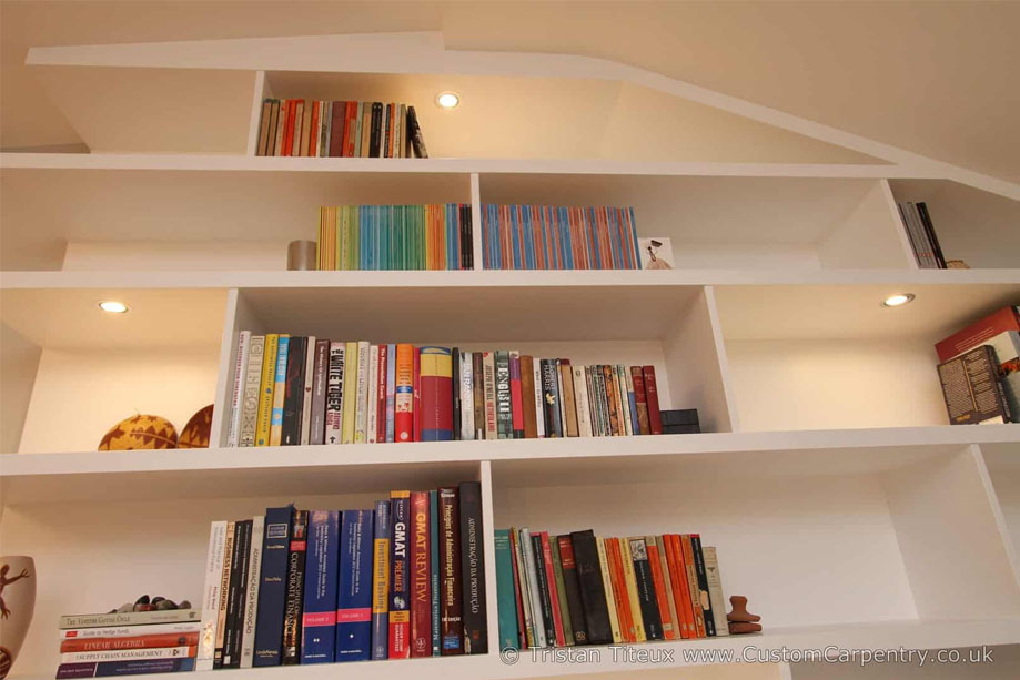 Bottom angle view of ceiling high library bookcase with accent LED light shelves all painted White