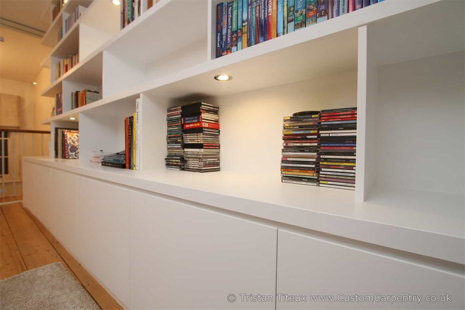 Bottom right view of custom asymmetrical bookcase with low closets all painted White