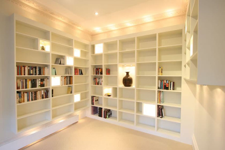 Full view of White handpainted bookcases with accent LED light shelves built on 3 walls