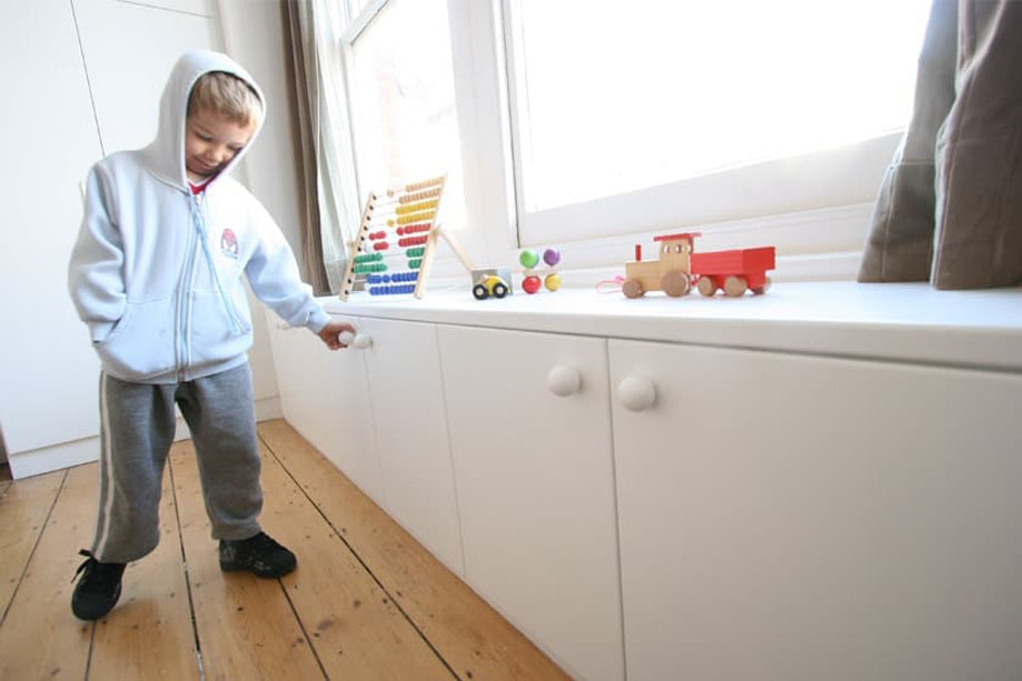 White painted low children's bedroom cupboards with round handles