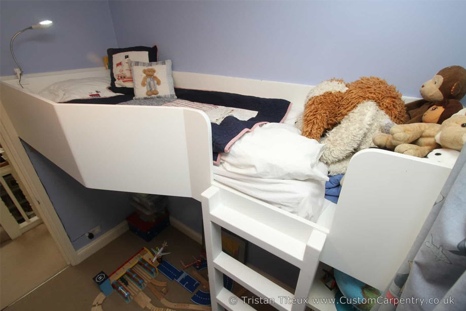 Spacious top bunk bed with chest at the foot and play area underneath inside children's room