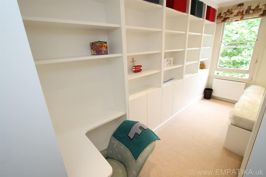 View of children's bedroom interiors with ceiling high storage shelves and corner shelf built on two walls