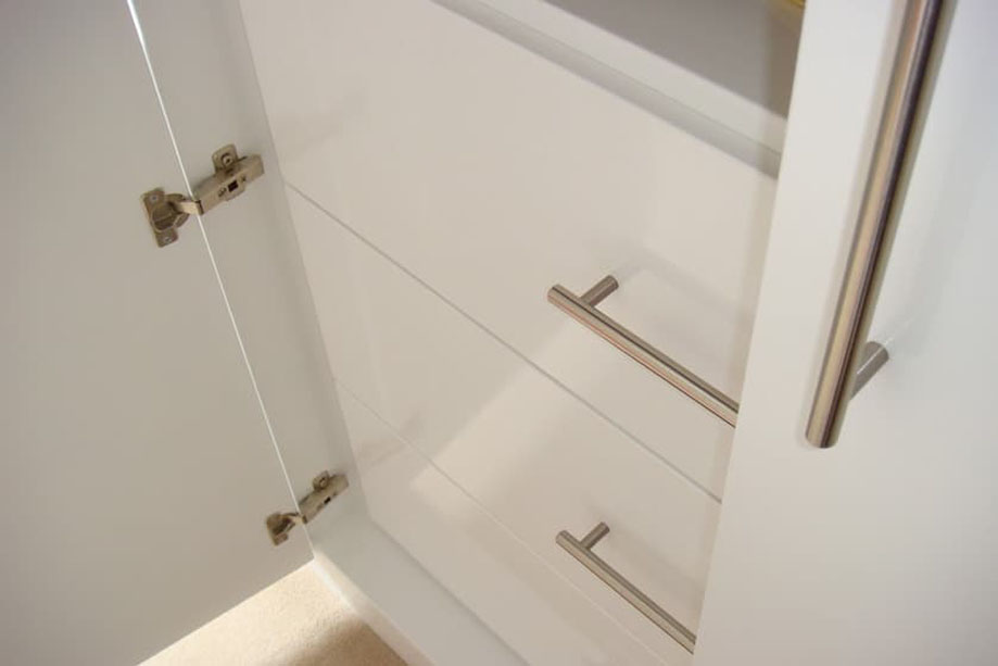 Interiors of bespoke wardrobes with European hinges and 3 drawers with steel bar handles