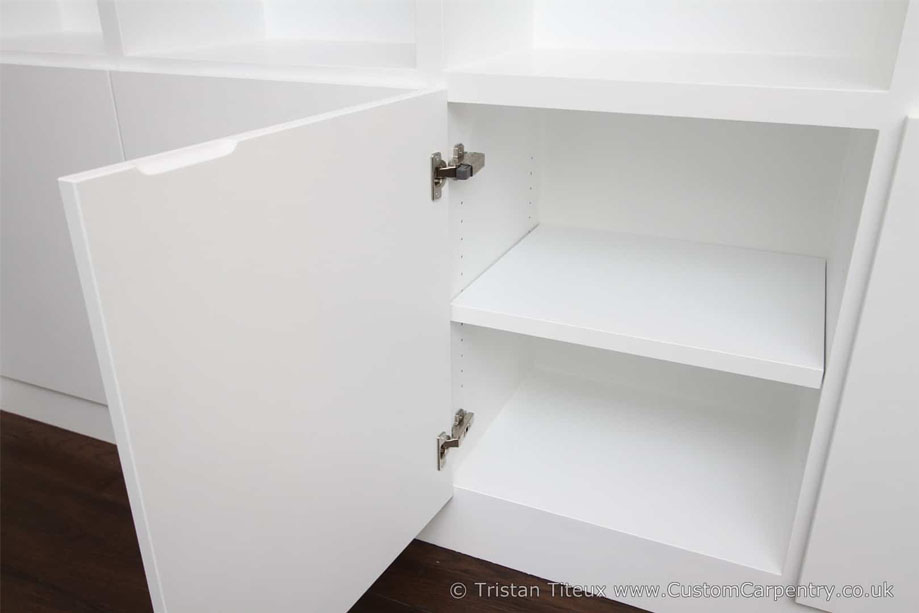 Interiors of custom display unit bottom closets with modern European hinges and adjustable shelf