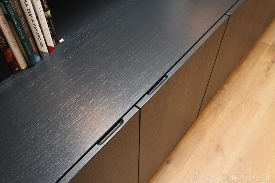 Close up of custom Black display unit with edge pocket doors on the bottom closets for easy opening