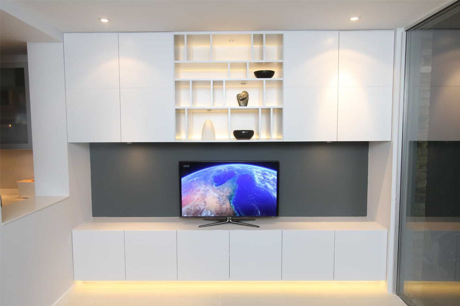 Bespoke White painted low TV media unit with 4 closets above and LED light display shelves