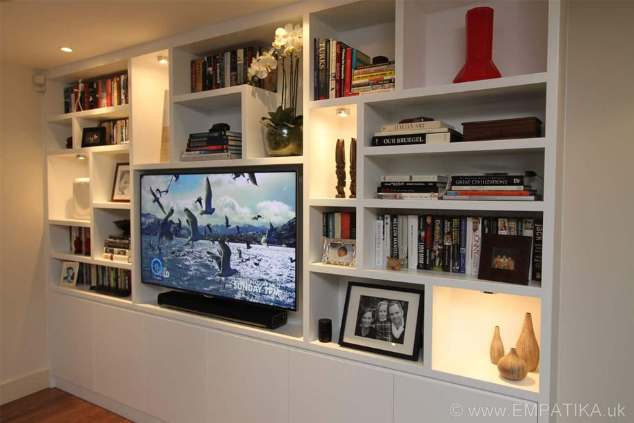 Right side view of contemporary White painted TV media unit with surrounding bookcase with LED lights