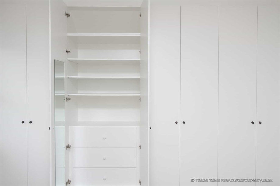 8-door White painted bedroom wardrobes with small steel bar handles and mirror and spacious storage shelves inside