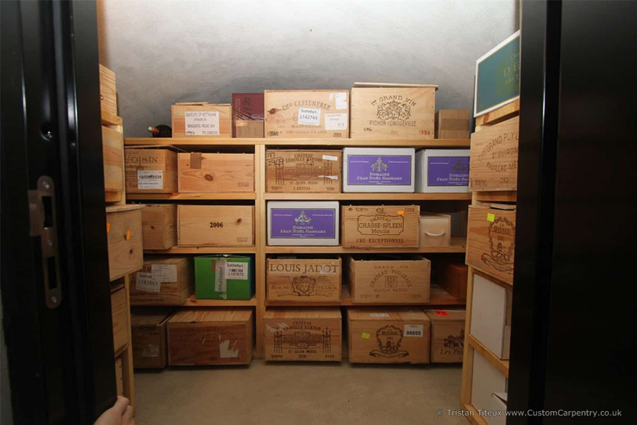 Interiors of bespoke walk-in eco-fitted wiine cellar with shelves for wine boxes