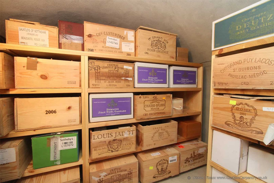 Custom eco-fitted walk-in wine cellar with prefinished shelves filled with wine boxes