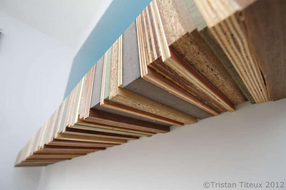 Bottom angle view of custom rustic floating shelf made from recycled wood boards