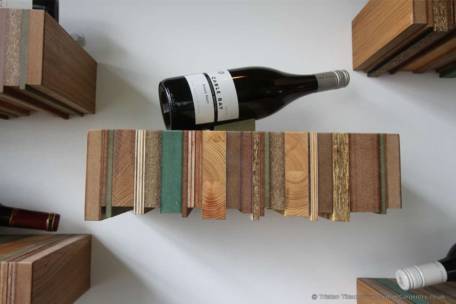 Close up view of eco-friendly floating shelf for wine bottle display made from recycled wood boards