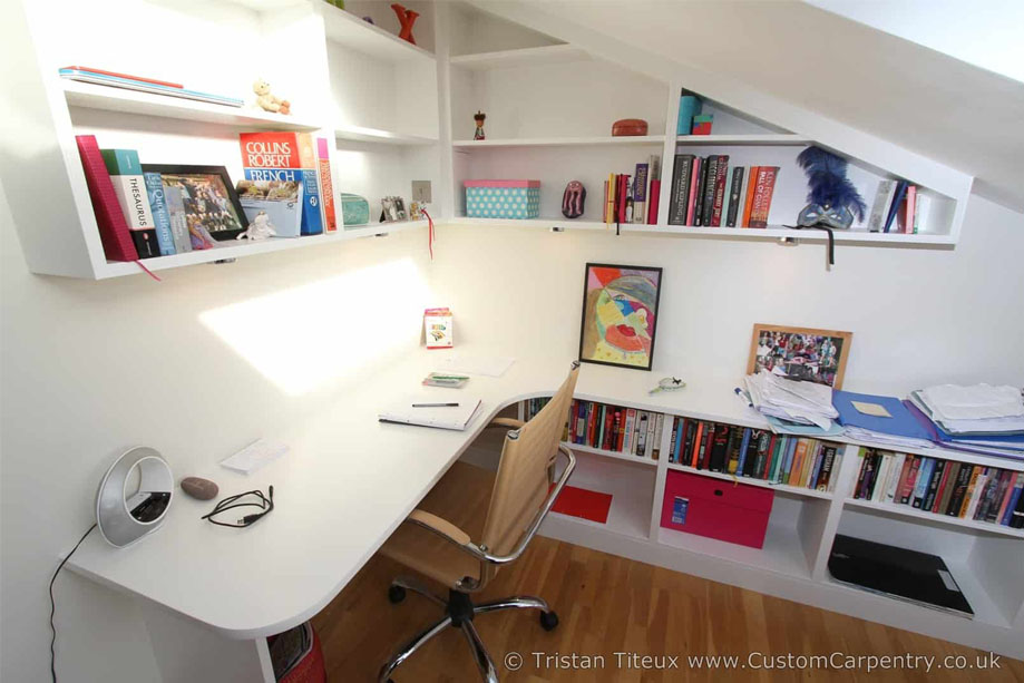 White painted home office with desk and custom overhead shelving