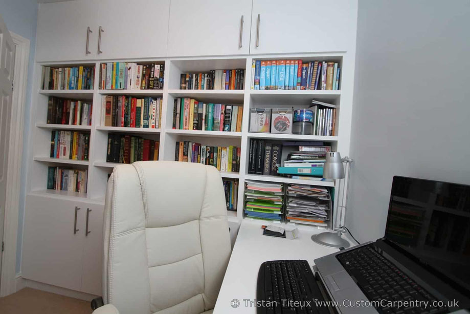 Wall to wall bookcase with 4-column shelves on the center and top and bottom closets with steel bar handles