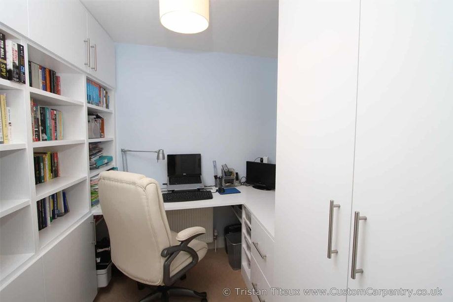 This fitted home office furniture consists of a wall to wall bookcase with closets on the left, a corner desk, and drawers and a tall cabinet on the right all painted White