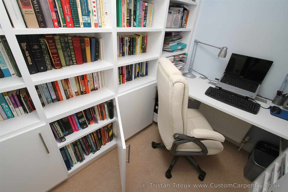 Built in White painted home office furniture with library bookcase and bottom cabinets showing more shelves inside
