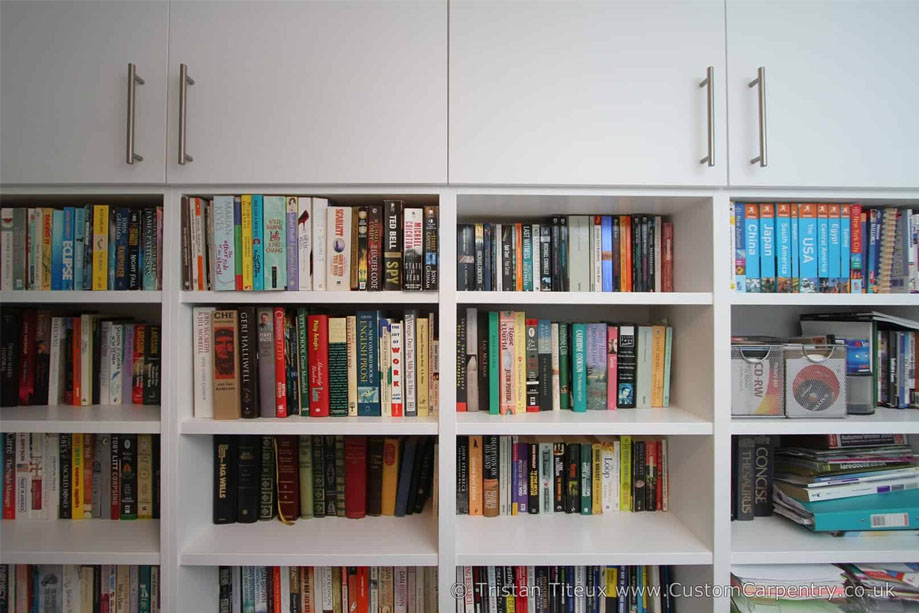 Fitted White painted wall to wall bookcase with spacious 4-column shelves with top closets with steel handle bars