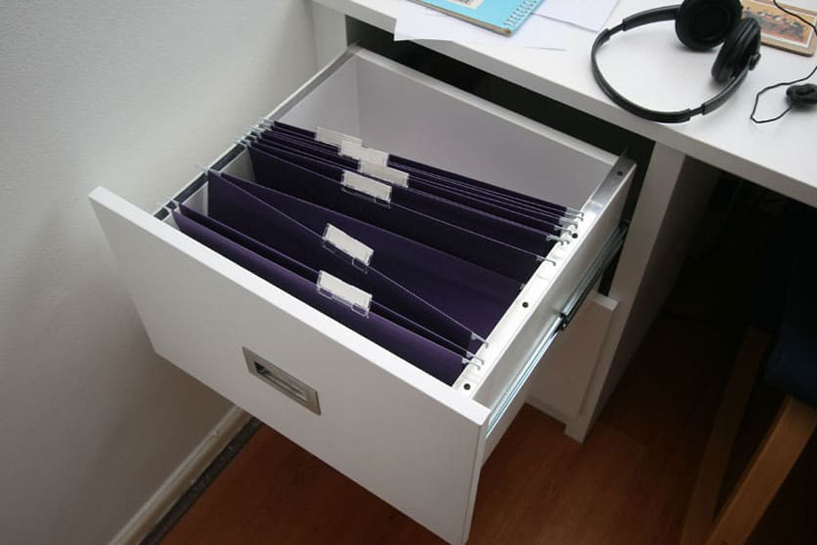 Close up view of White painted built in desk drawers with steel pocket handles and spacious interiors