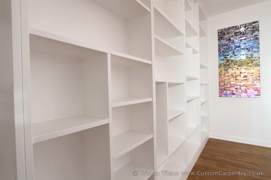 Left side view of custom wall to wall library bookcase with spacious asymmetrical shelves