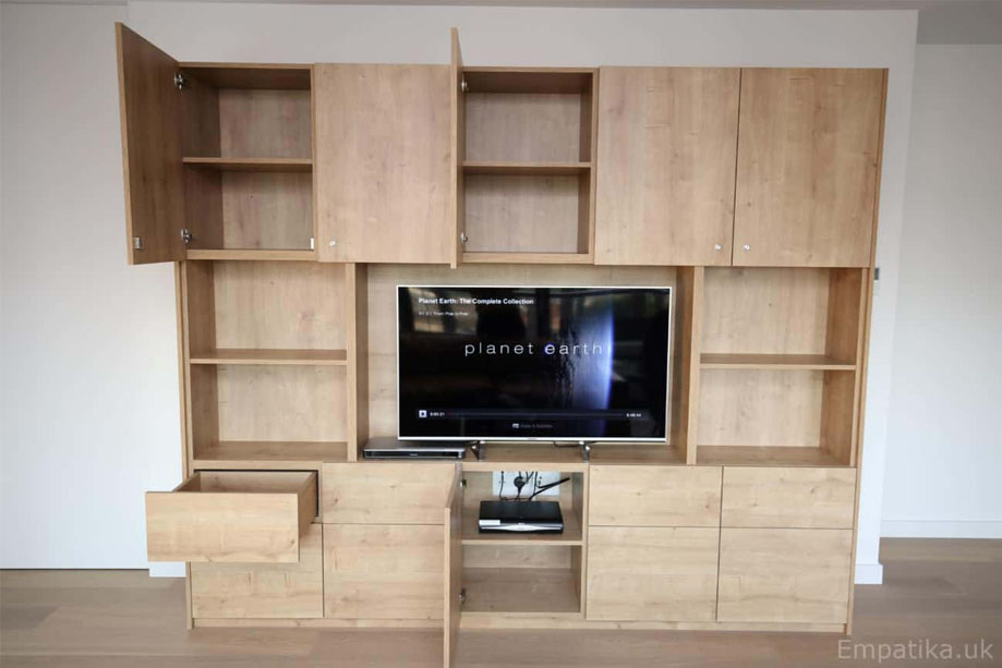 Custom prefinished TV media unit with top and bottom cupboards and open shelving in the middle