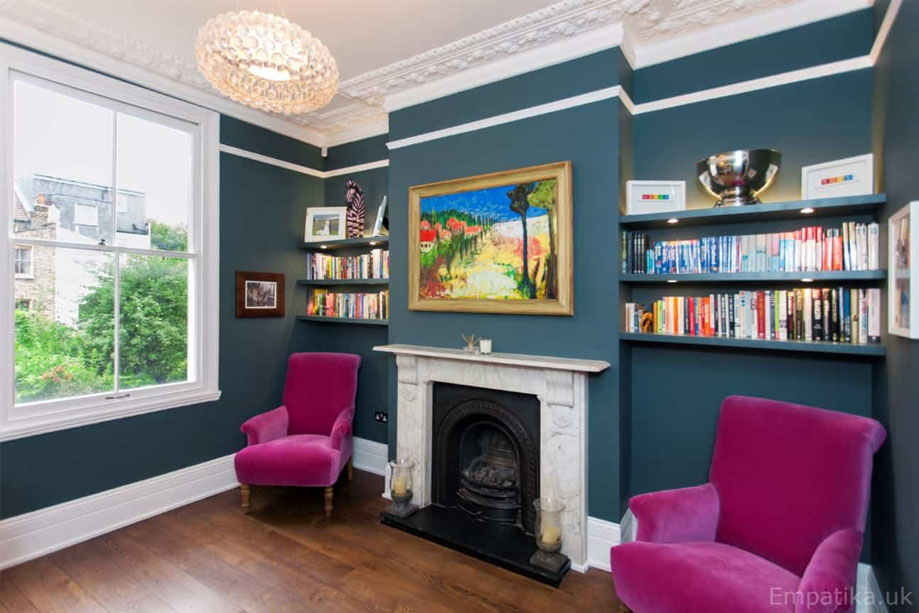 Side view of dark painted floating alcove shelves with LED lights on each side of a freplace