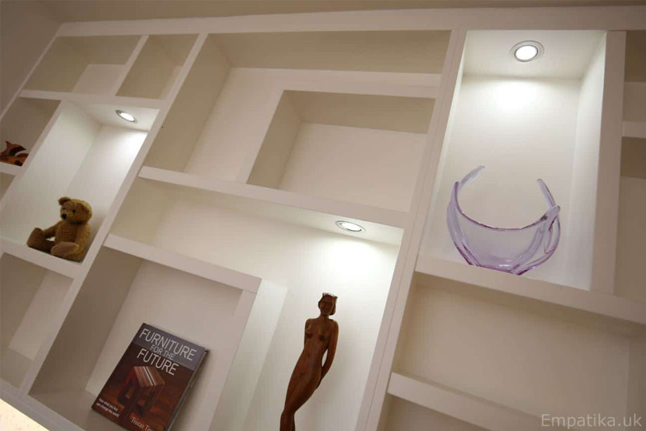 Closer look at White painted TV media unit with asymmetrical shelves and ambient LED lights